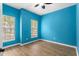 This bedroom has blue walls, hardwood floors, natural lighting, and a ceiling fan at 922 Jasmine St, Celebration, FL 34747