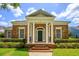 Inviting brick home with a columned entrance, green door, and beautifully maintained landscaping at 922 Jasmine St, Celebration, FL 34747