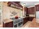 Gourmet kitchen featuring stainless steel appliances, a custom range hood, and beautiful countertops at 922 Jasmine St, Celebration, FL 34747