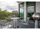 Cozy balcony with a small table, metal chairs, a grill, and a view of the neighborhood greenery at 10 N Summerlin Ave # 14, Orlando, FL 32801