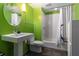 Fresh bathroom with bright green walls, white fixtures, modern sink, and a shower with a white tiled tub at 10 N Summerlin Ave # 14, Orlando, FL 32801