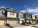 Charming townhomes featuring colorful siding, brick driveways, and attached garages in a well-maintained community at 1003 E 10 St, Apopka, FL 32703