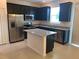 Modern kitchen with granite countertops, stainless steel appliances, dark cabinetry and an island at 1003 E 10 St, Apopka, FL 32703