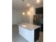 Kitchen with island and granite countertops, stainless steel appliances and neutral colors, and modern lighting fixtures at 1003 E 10 St, Apopka, FL 32703