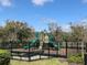 Community playground with slides, climbing structures, benches, and a secure fenced perimeter for safety at 1003 E 10 St, Apopka, FL 32703
