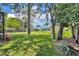 Large, grassy backyard with mature trees and partial fencing for added privacy at 1181 Pine Ln, St Cloud, FL 34771