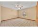 Spacious bedroom featuring tile flooring, neutral walls, a ceiling fan, and a window for natural light at 1181 Pine Ln, St Cloud, FL 34771