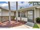 Cozy front porch enhanced by a brick accent wall and lush, tropical landscaping at 1181 Pine Ln, St Cloud, FL 34771