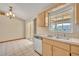 Bright kitchen featuring a stainless dishwasher, double sinks, and a window overlooking the screened-in patio at 1181 Pine Ln, St Cloud, FL 34771