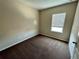 Neutral bedroom featuring neutral walls, brown carpeting, and a window for ample natural light at 12359 Langstaff Dr, Windermere, FL 34786