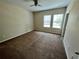 Spacious bedroom featuring neutral walls, brown carpeting, two windows and a ceiling fan at 12359 Langstaff Dr, Windermere, FL 34786