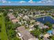 Aerial of a neighborhood featuring a pond with a fountain, homes with varied architecture, and tree-lined streets at 12938 Maribou Cir, Orlando, FL 32828