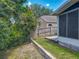 View of the backyard with lush landscape, wooden fence, and screened-in porch at 12938 Maribou Cir, Orlando, FL 32828