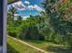 Landscaped backyard with lush greenery and bright blue sky overhead at 12938 Maribou Cir, Orlando, FL 32828