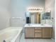 Bright bathroom featuring double sinks, tile floors, a large mirror and bath at 12938 Maribou Cir, Orlando, FL 32828