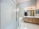 Well-lit bathroom with tiled floors, double sink vanity, a bathtub, and glass shower at 12938 Maribou Cir, Orlando, FL 32828