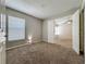 Neutral carpeted bedroom featuring bright light from the window and entry to the next room at 12938 Maribou Cir, Orlando, FL 32828