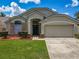 Charming single-Gathering home featuring a well-manicured lawn and an attached two-car garage at 12938 Maribou Cir, Orlando, FL 32828