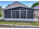 Exterior view of screened lanai with brick landscaping and grassy area at 12938 Maribou Cir, Orlando, FL 32828