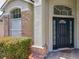 Inviting entryway with brick accents, lush landscaping, and a stylish black front door at 12938 Maribou Cir, Orlando, FL 32828