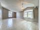 Bright living room featuring a vaulted ceiling, arched windows, and neutral paint at 12938 Maribou Cir, Orlando, FL 32828