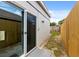 Side yard featuring a sliding glass door, wooden fence, grass, and access to backyard at 1358 Brookebridge Dr, Orlando, FL 32825