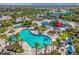 Aerial view of the resort featuring a large pool, seating areas, palm trees, and landscaping at 1409 Bellamy Dr, Reunion, FL 34747