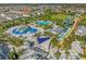 Aerial view of the resort featuring a water park, pools, palm trees, and neighborhood at 1409 Bellamy Dr, Reunion, FL 34747