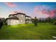 Spacious backyard featuring a well-maintained lawn, fence, and sliding glass door entrance at 1409 Bellamy Dr, Reunion, FL 34747