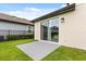 Exterior back patio with sliding glass doors and a well-manicured lawn, offering a seamless indoor-outdoor transition at 1409 Bellamy Dr, Reunion, FL 34747