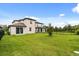 Spacious backyard featuring a well-maintained lawn, fence, and sliding glass door entrance at 1409 Bellamy Dr, Reunion, FL 34747
