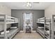 This bedroom includes three sets of bunk beds, a ceiling fan, and a window, perfect for a spacious and comfortable stay at 1409 Bellamy Dr, Reunion, FL 34747