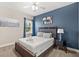 Cozy bedroom featuring a full-size bed, with cool blue walls, and a bright window for a serene ambiance at 1409 Bellamy Dr, Reunion, FL 34747
