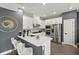 Modern kitchen featuring white cabinets, stainless steel appliances, a quartz countertop island with seating, and stylish finishes at 1409 Bellamy Dr, Reunion, FL 34747