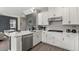 Bright kitchen with stainless steel appliances, white cabinets, quartz countertops, and hardwood floors, offering ample counter space at 1409 Bellamy Dr, Reunion, FL 34747