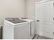 Laundry room equipped with modern washing machines and a convenient side-access door at 1409 Bellamy Dr, Reunion, FL 34747