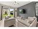 Living room with a sliding glass door to backyard, modern furniture, and a gray accent wall with mounted TV at 1409 Bellamy Dr, Reunion, FL 34747