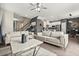 Spacious living room with hardwood floors, modern furniture, and seamless flow into the adjacent kitchen and dining areas at 1409 Bellamy Dr, Reunion, FL 34747
