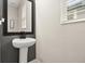 Cozy powder room featuring a pedestal sink, modern fixtures, and soft natural lighting at 1409 Bellamy Dr, Reunion, FL 34747