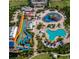 Aerial view of a water park with a variety of colorful slides and pool, surrounded by lush landscaping and amenities at 1409 Bellamy Dr, Reunion, FL 34747