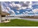 Backyard with green lawn, white fence, covered patio area, and neighborhood views beyond at 165 Lavenna Ave, St Cloud, FL 34771