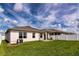 Green backyard with covered patio and white privacy fence featuring an exterior view of the home at 165 Lavenna Ave, St Cloud, FL 34771