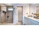 Bright bathroom featuring a walk-in shower, tiled walls, and double sink vanity at 165 Lavenna Ave, St Cloud, FL 34771