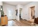 Welcoming entryway with wood-look floors, decorative shelving, and access to the bathroom at 165 Lavenna Ave, St Cloud, FL 34771