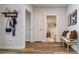 Bright hallway featuring wood-look flooring, coat rack, and doorway views to the bathroom with framed art at 165 Lavenna Ave, St Cloud, FL 34771