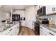 Well-lit kitchen boasts white cabinets, stainless steel appliances, and elegant granite countertops at 165 Lavenna Ave, St Cloud, FL 34771