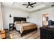 Spacious main bedroom with tray ceiling, dark wood furniture, and ensuite bathroom at 165 Lavenna Ave, St Cloud, FL 34771