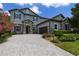 Charming two-story home featuring stone accents, an attached garage, and a paver driveway enhanced by lush landscaping at 17551 Black Rail St, Windermere, FL 34786