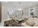 Spacious living room with a long mirrored wall, modern decor, and elegant lighting leading into the kitchen and dining at 17551 Black Rail St, Windermere, FL 34786