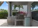Outdoor kitchen complete with stainless steel grill, mini fridge, and stone countertop at 17551 Black Rail St, Windermere, FL 34786